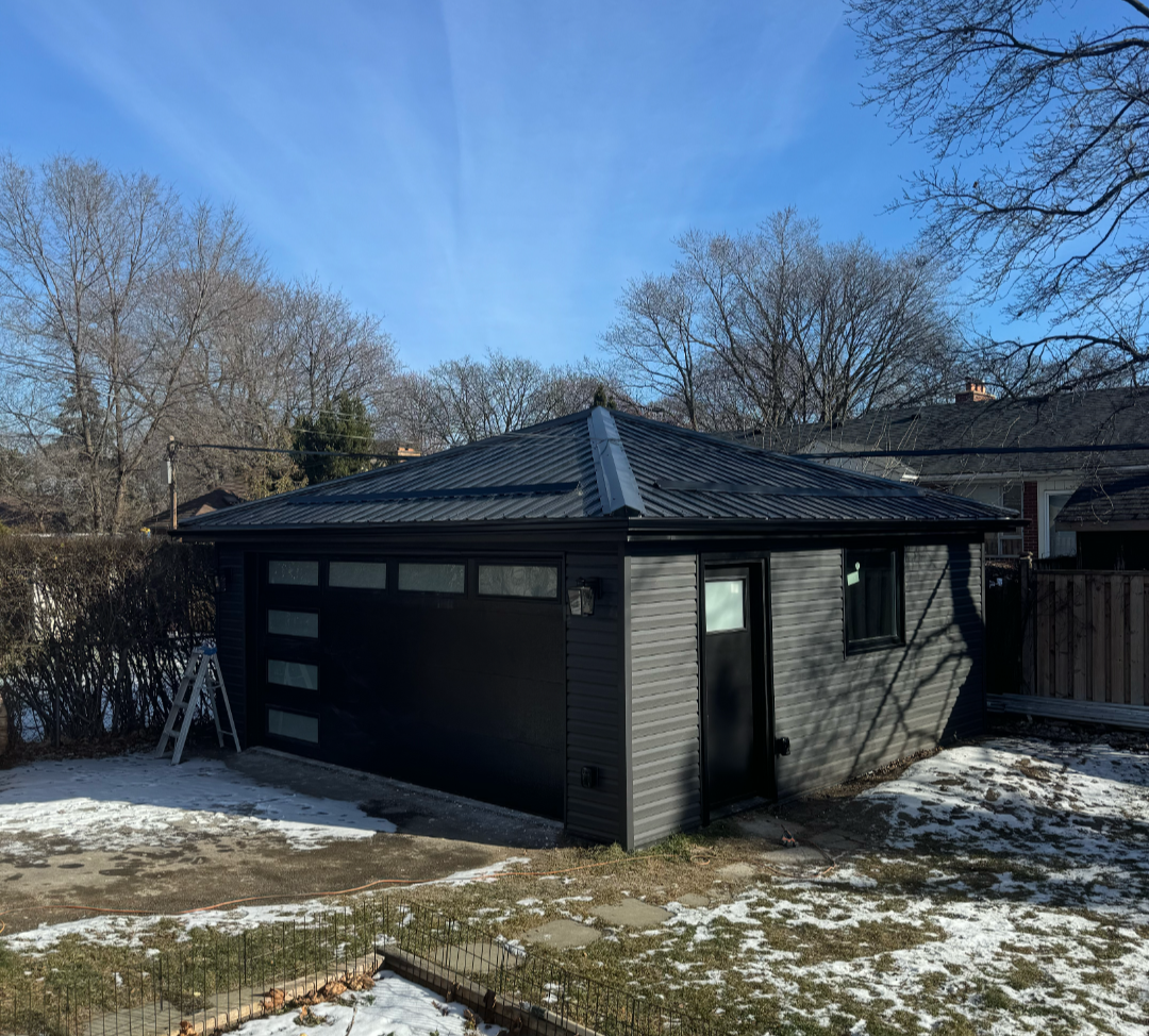 Modern black detached garage with metal roof and glazed door panels