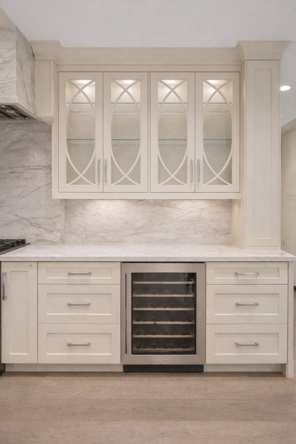 Classic white kitchen bar area with illuminated glass cabinetry, marble backsplash and built-in wine fridge in Richmond Hill