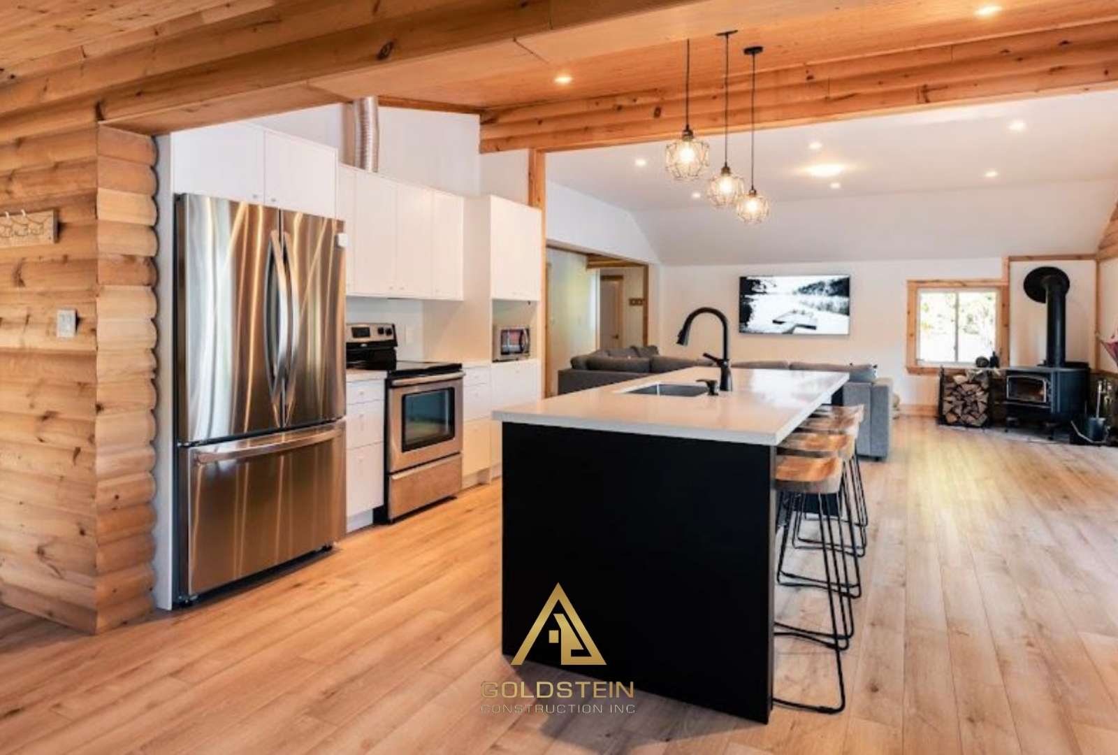 Open-concept log cottage kitchen with white cabinetry and black island