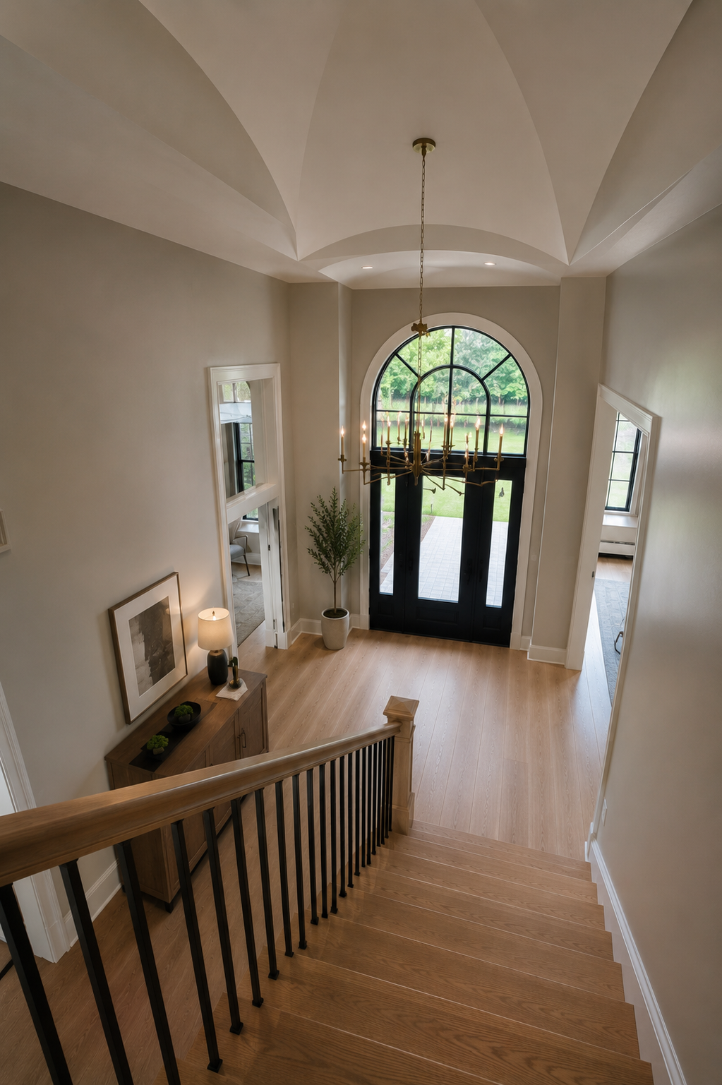 Two-storey entryway of a Goldstein custom home in Richmond Hill with vaulted plaster ceiling, arched steel window and white oak stair