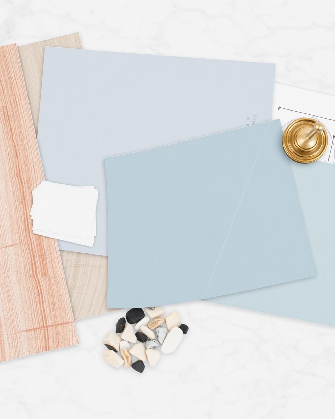Bathroom remodel material samples and drawings on a marble surface
