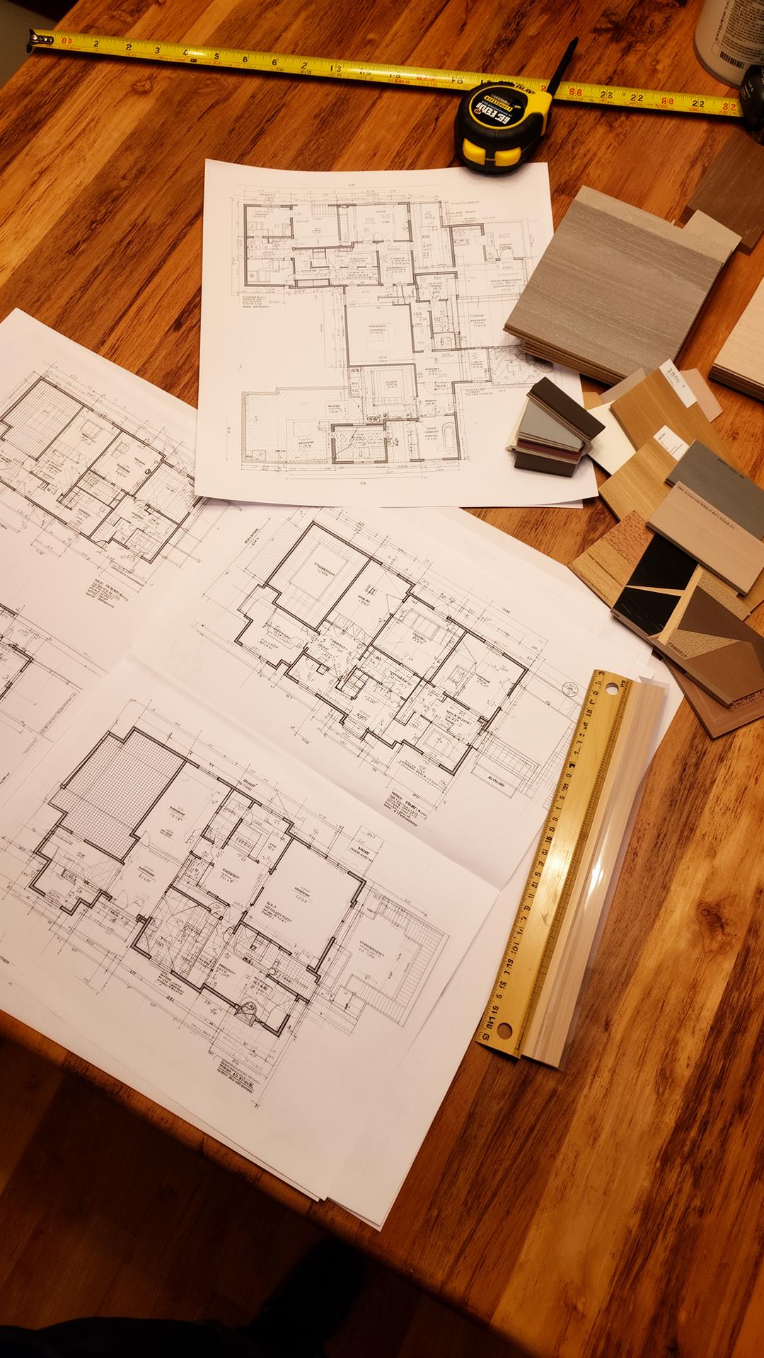 Home addition floor plans, drawings and material samples on a wood table